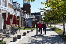 three women standing on the sidewalk of a building